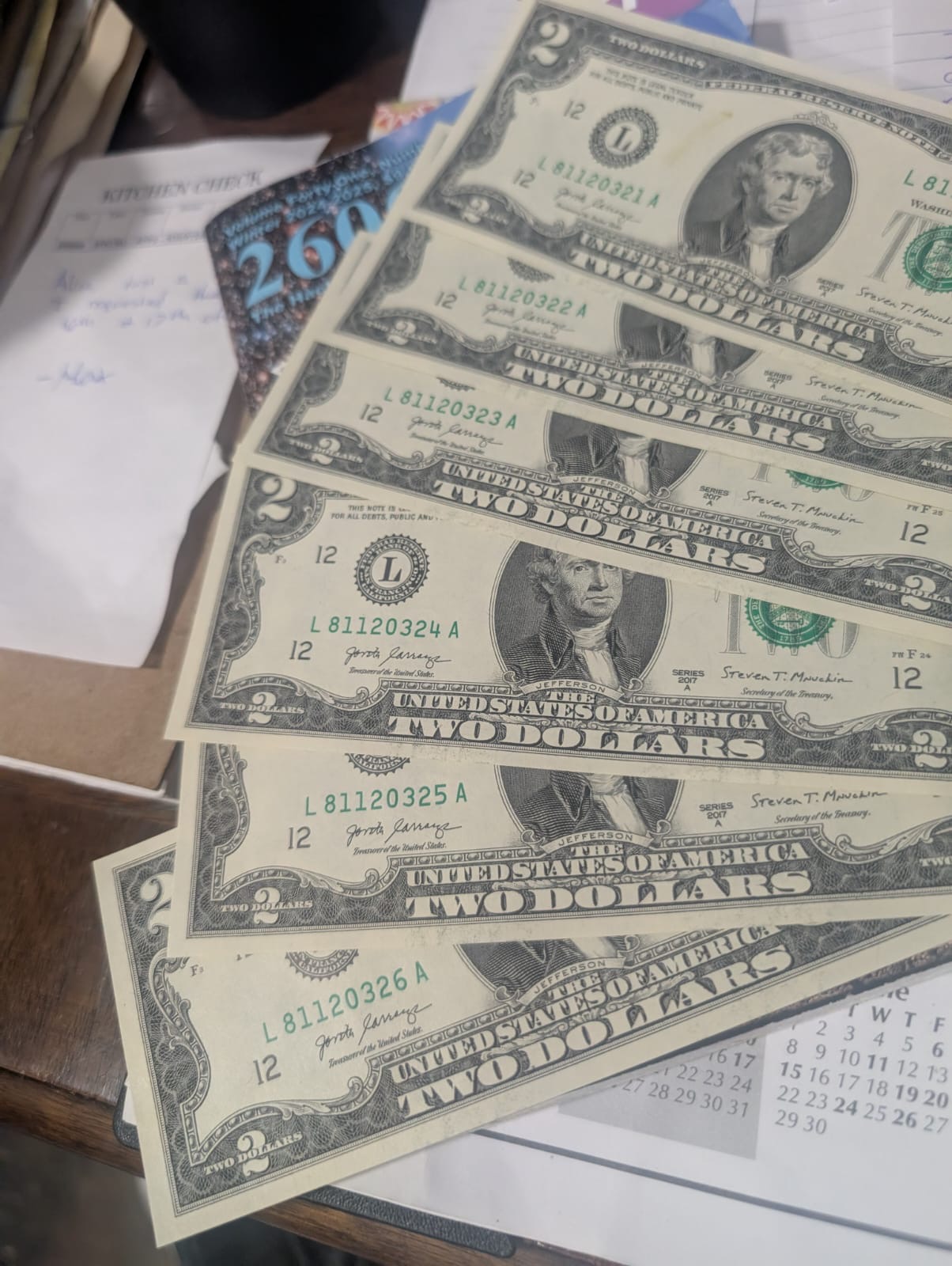 Fan of sequential $2 bills showing consecutive serial numbers